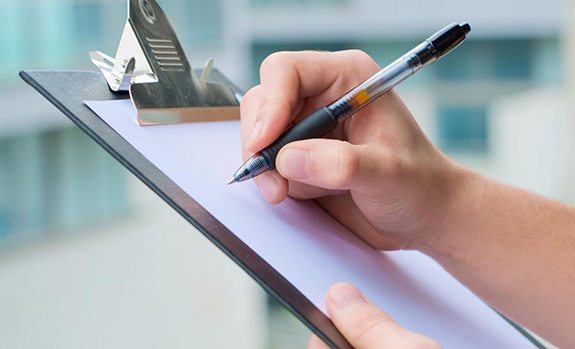 woman writing on clipboard