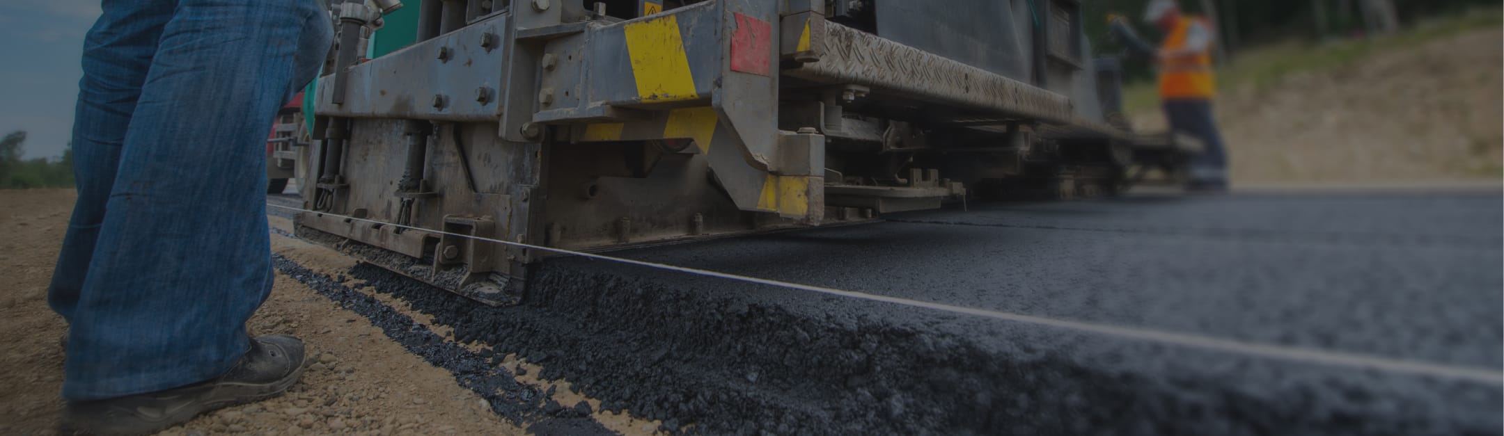 close up of lets pave workers smoothing out new asphalt